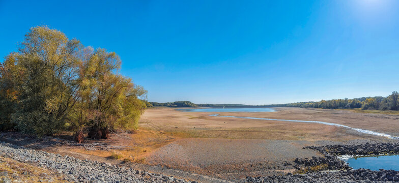 Lake of Michelbach between Aspach-le-Bas and Michelbach in southern Alsace. Seen from the small dike to the main dike during periods of low water, bordered by sandy banks and wild vegetation