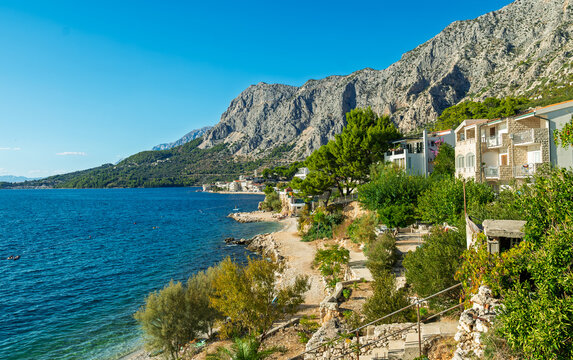 Scenic view of coastal town along the Adriatic Sea in Croatia with mountains, clear blue water, and Mediterranean architecture