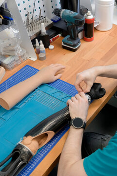 Specialist inspects a carbon fiber prosthetic socket and artificial limb components.