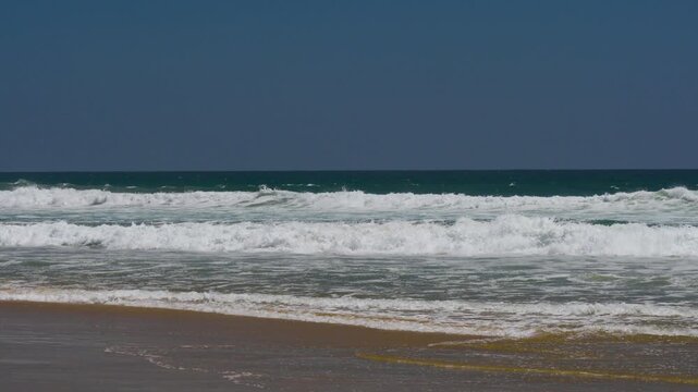 Waves rolling in to an empty beach in california