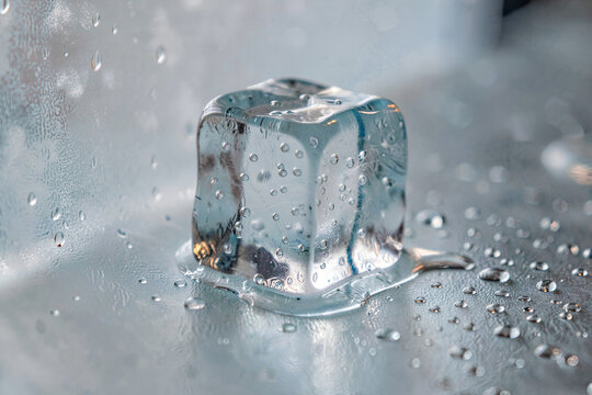Macro shot of a translucent pale blue ice cube on frosted glass with soft refractions