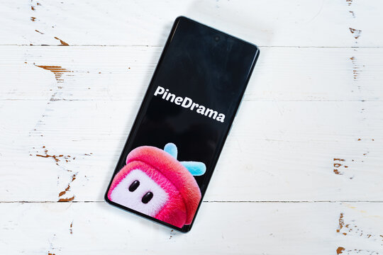 ZhongShan GuangDong China-October 11 2026: Smartphone lying on white wooden table showing PineDrama mascot splash screen at horizontal composition.