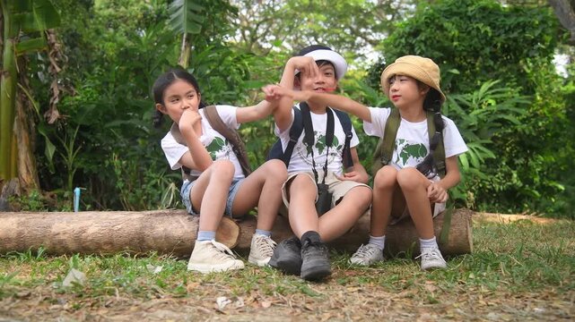 Children with binoculars holds hands and looks into distance and something joyfully screams they are wearing save world t-shirt with forest nature summer travel holiday concept.