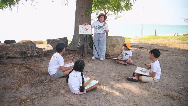 Group of teacher and school children on ecotourist trip  learning show beach take care of environment.