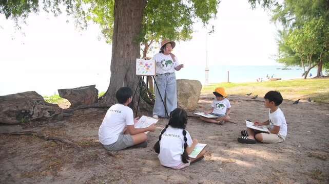 Group of teacher and school children on ecotourist trip  learning show beach take care of environment.