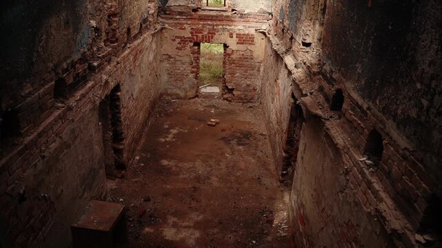 Abandoned brick building interior with crumbling walls and open
