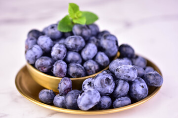 Fresh blueberries in a metal bowl on a white background. Close-up.  © Olivka888