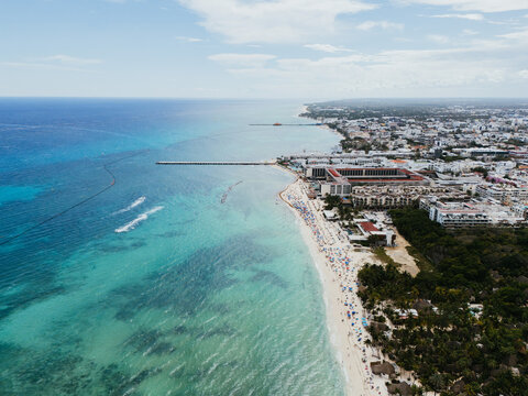 Drone view of coastal Mexican city with pier and turquoise shoreline