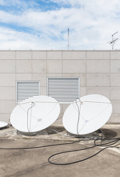 White Satellite Dishes on Building Rooftop under Blue Sky