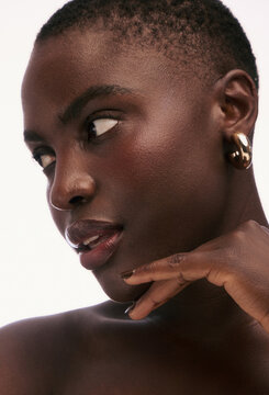 Model Poses With Hand on Chin in Studio Setting