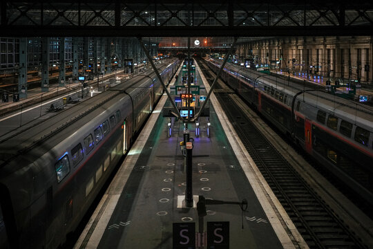 Empty train platforms at night inside a large station