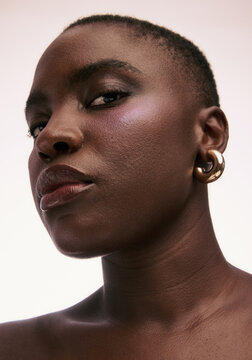 Portrait of a Person With Short Hair and Earrings in Studio Setting
