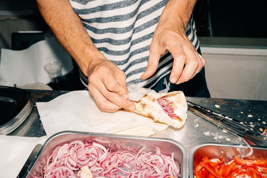 Man Prepares Food With Vegetables at a Kitchen Counter