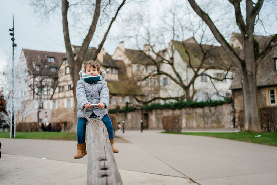 A toddler boy has fun at the playground in town