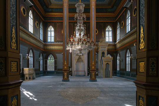 Interior of Yildiz Hamidiye Mosque, an 1886 Ottoman landmark in Istanbul, Turkey, with crystal chandelier, Gothic arched windows, and white marble mihrab and minbar