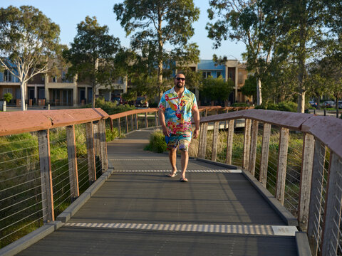 Maori Man Walking on a Wooden Path in a Park During the Evening
