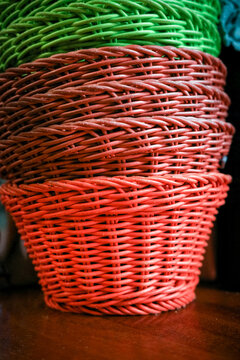 Colourful wicker baskets stacked on a wooden shelf
