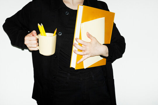 Person holding only all yellow office tools and supplies in workplace