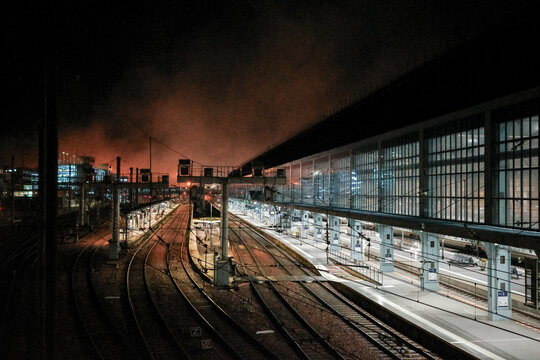 Empty train station platforms at night with glowing sky