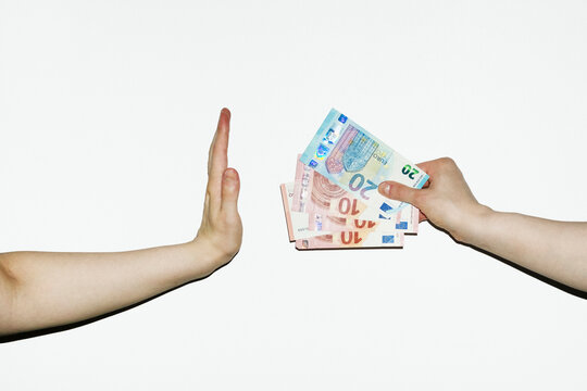 Person rejecting money cash payment that other person offers