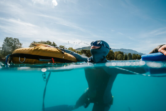 playful freediver spitting water at the lake surface
