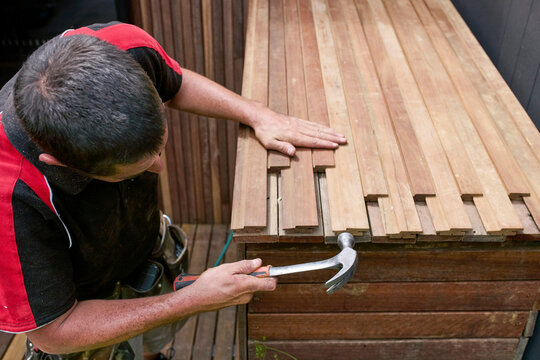 Carpenter Working on Wooden Planks During Construction Project