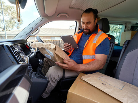 Delivery Driver Checks Packages in Vehicle at Delivery Location