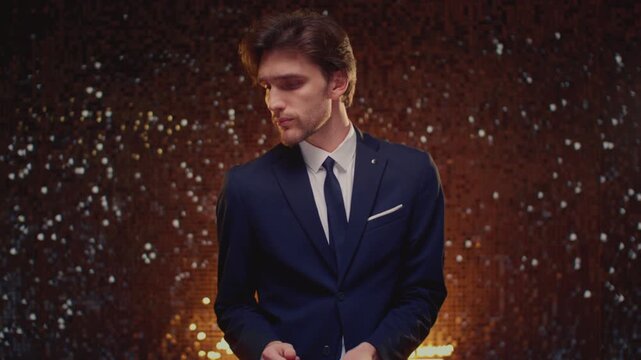 Attractive man in business suit is dancing. Young handsome male in a tailcoat is enjoying at a celebration. Retro disco dance party for New Year or birthday. Stylish moves at event, and having fun.