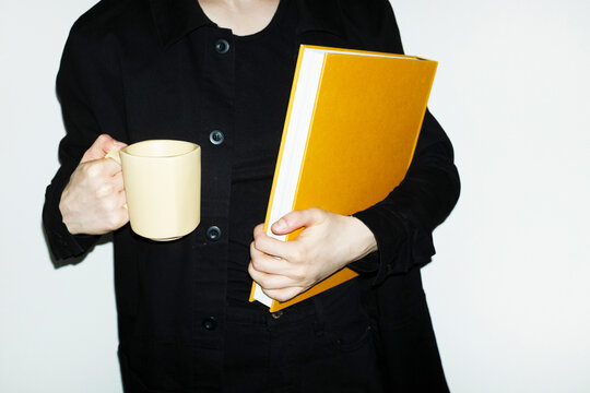 Person holding only all yellow office tools and supplies in workplace