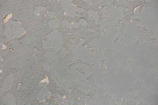 Abstract textured background of grey peeling paint on a surface