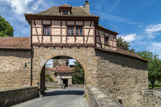 
Rothenburg ob der Tauber, Bavaria, Germany. R&ouml;dertor medieval gate with half-timbered upper level, tiled gable roof, stone archway and bridge crossing the former defensive moat.