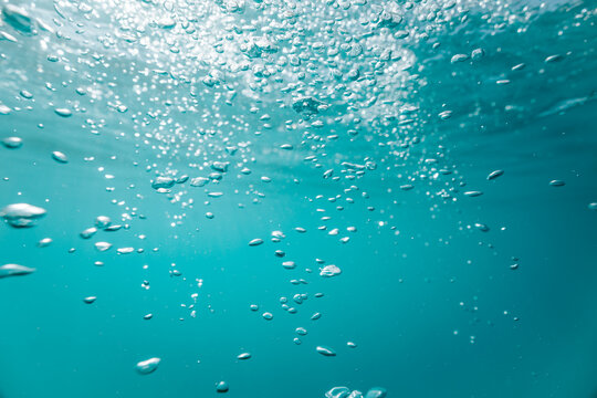 scattered bubbles suspended in turquoise lake water