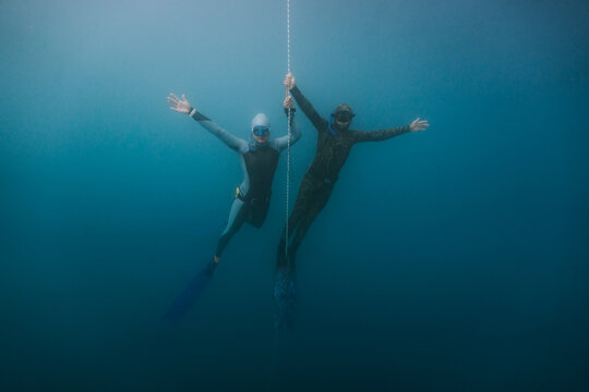 freediving friends floating playfully underwater