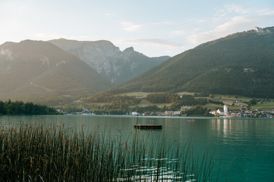 Small wooden float resting on calm water with alpine scenery in