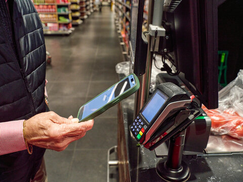 Person Using a Phone to Make a Payment at a Store Checkout