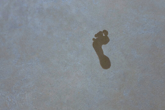 Conceptual image step footprint on a brown ground with soft sunlight