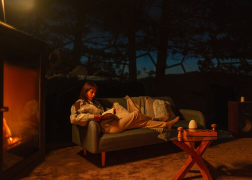Cozy Woman Reading by a Wood-Burning Stove