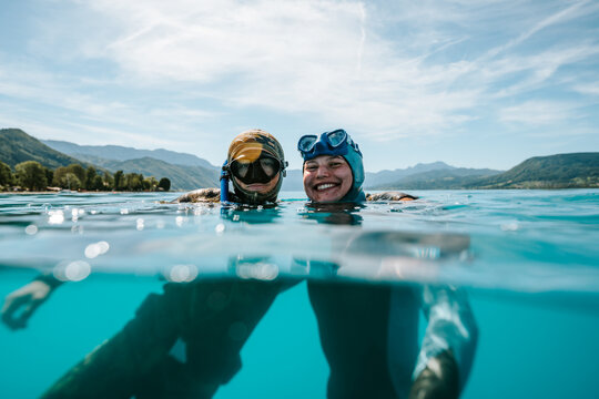 two freedivers smiling together at the lake surface