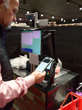 Man Using a Card Reader for Payment in Grocery Store Checkout