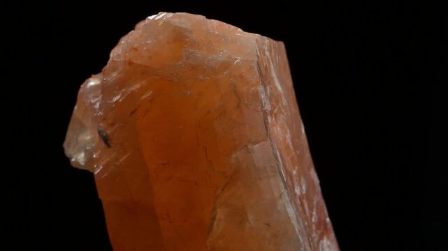 Orange Calcite crystals rotating slowly against a black background
