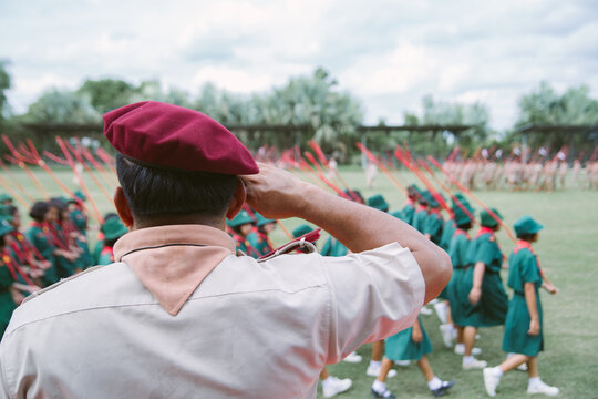 Rear View of Scoutmaster Saluting During Student Scout Parade Review on School Field
