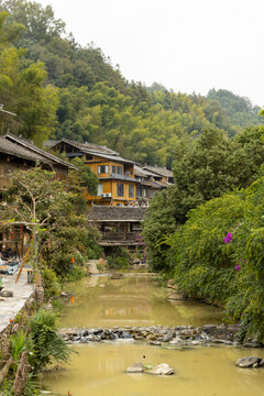 Traditional Wooden Stilt Houses Along River And Bamboo Forest In Zhaoxing Dong Village Guizhou China