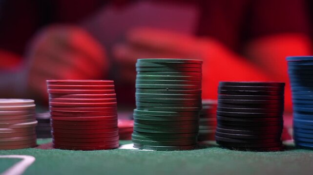 Poker chips in various colors stack on green felt
