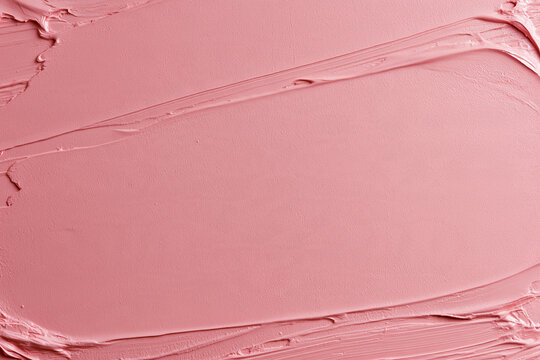 Pink cosmetic cream creating an elegant texture with brush strokes. Perfect background for beauty, skincare, and makeup products
