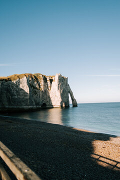 White chalk cliffs at Etretat beach during a sunny afternoon with clear blue sky over the ocean
