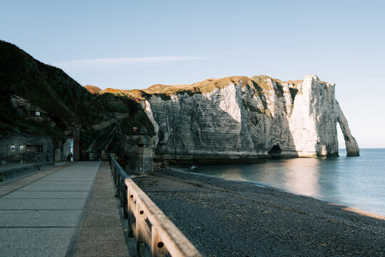 Chalk cliffs and pebble beach landscape at Etretat in Normandy during a bright sunny morning