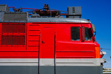 Red electric locomotive against blue sky. © SGr