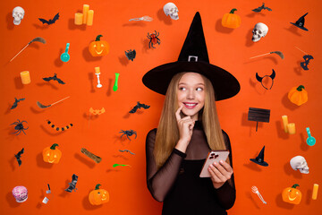 Photo of tricky cunning lady wear black wizard costume cap typing halloween greetings looking empty space isolated orange color background © deagreez