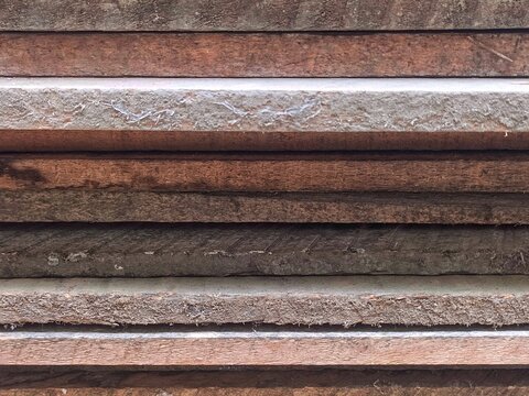 Horizontal stack of raw wooden planks forming natural timber texture background