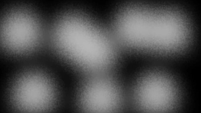 Black and white noisy blur gradient spots loop background, abstract grainy light leak motion